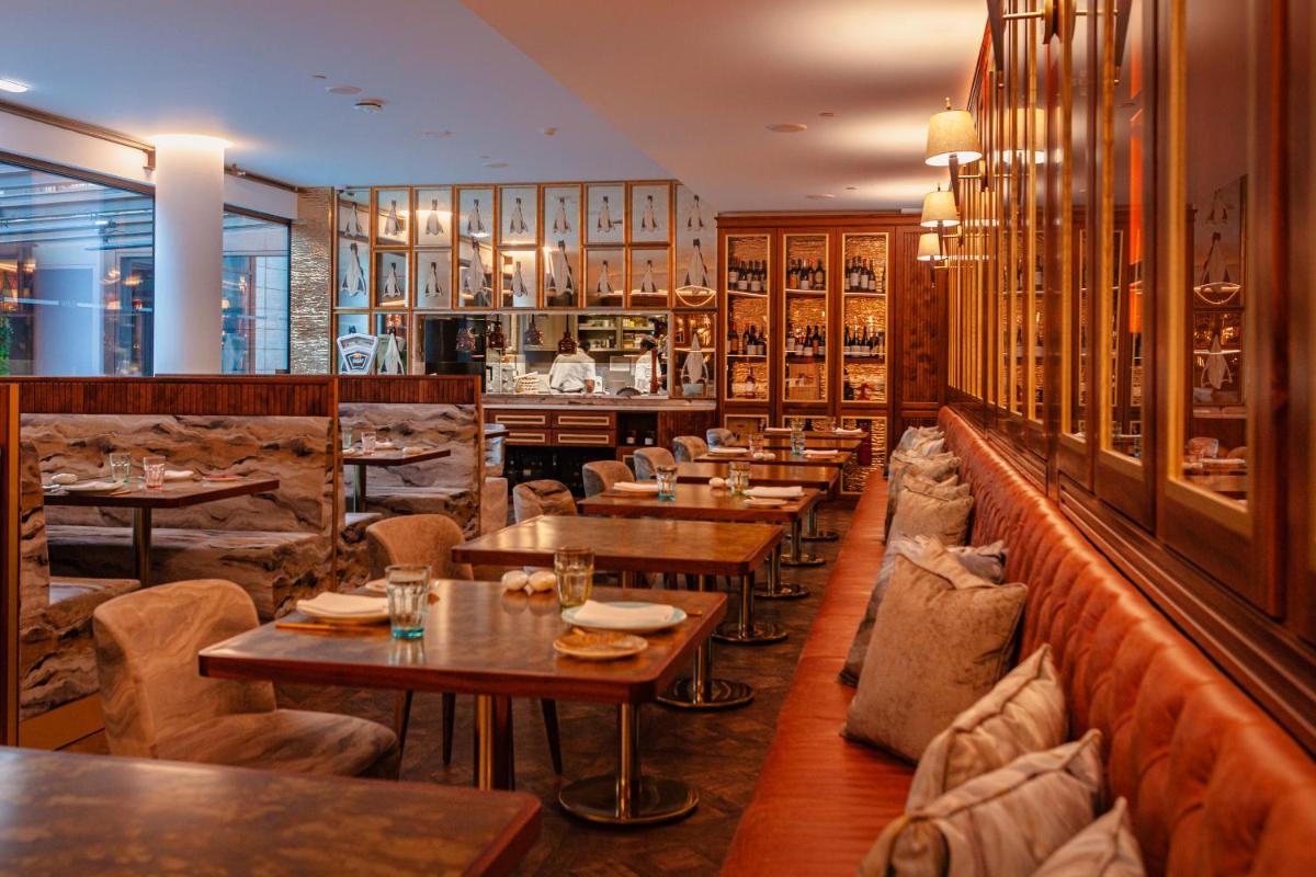 um restaurante com mesas e cadeiras e um bar em Wine & Books Lisboa Hotel em Lisboa