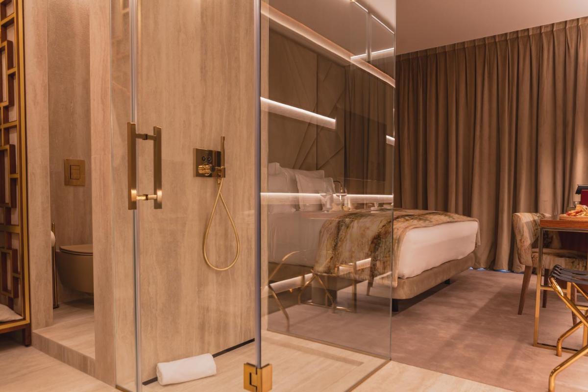 um banheiro com chuveiro e uma cama em um quarto em Wine & Books Lisboa Hotel em Lisboa mais 28 fotografias