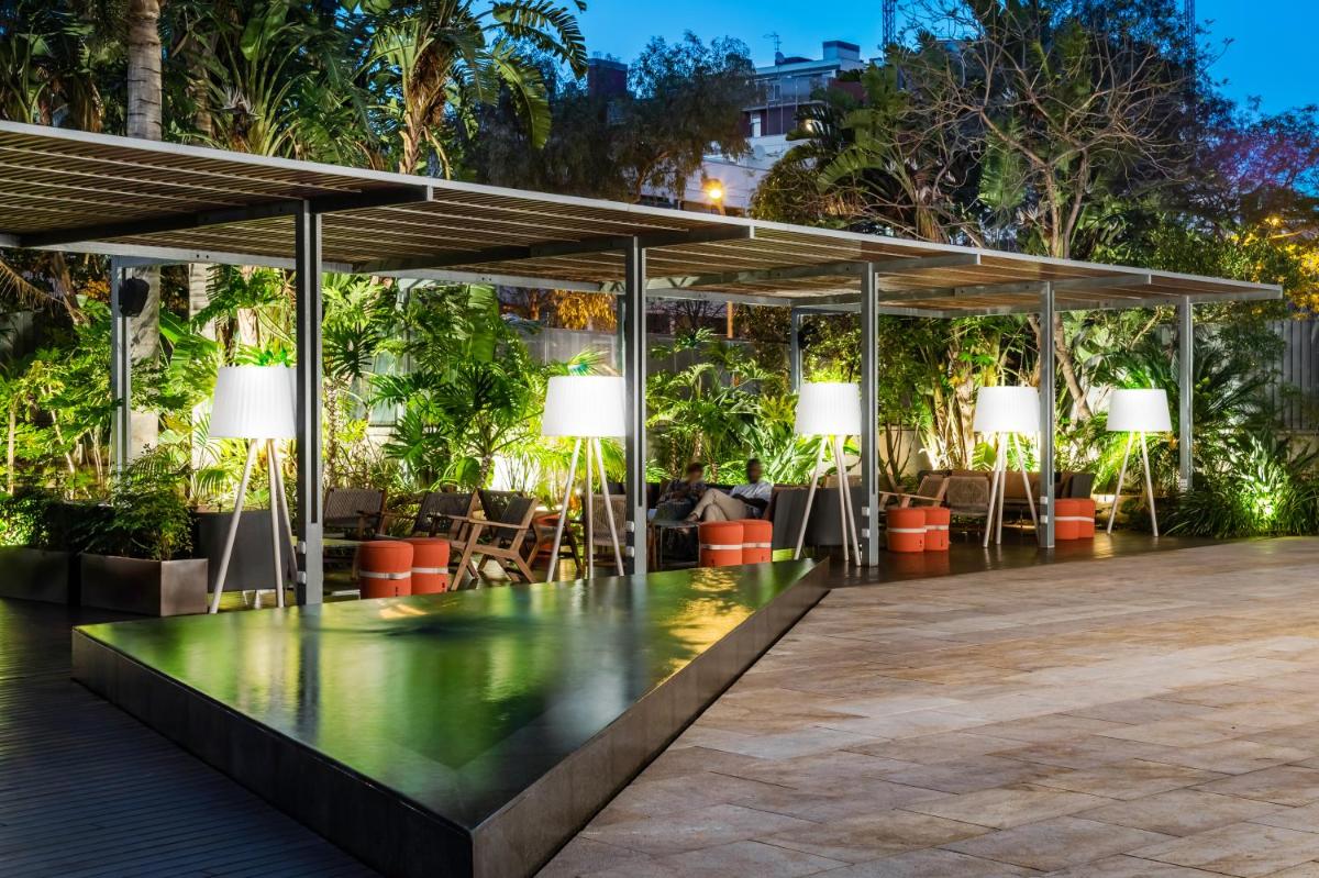 Un patio con mesas, sillas y luces. en Hotel SB Diagonal Zero 4 Sup, en Barcelona
