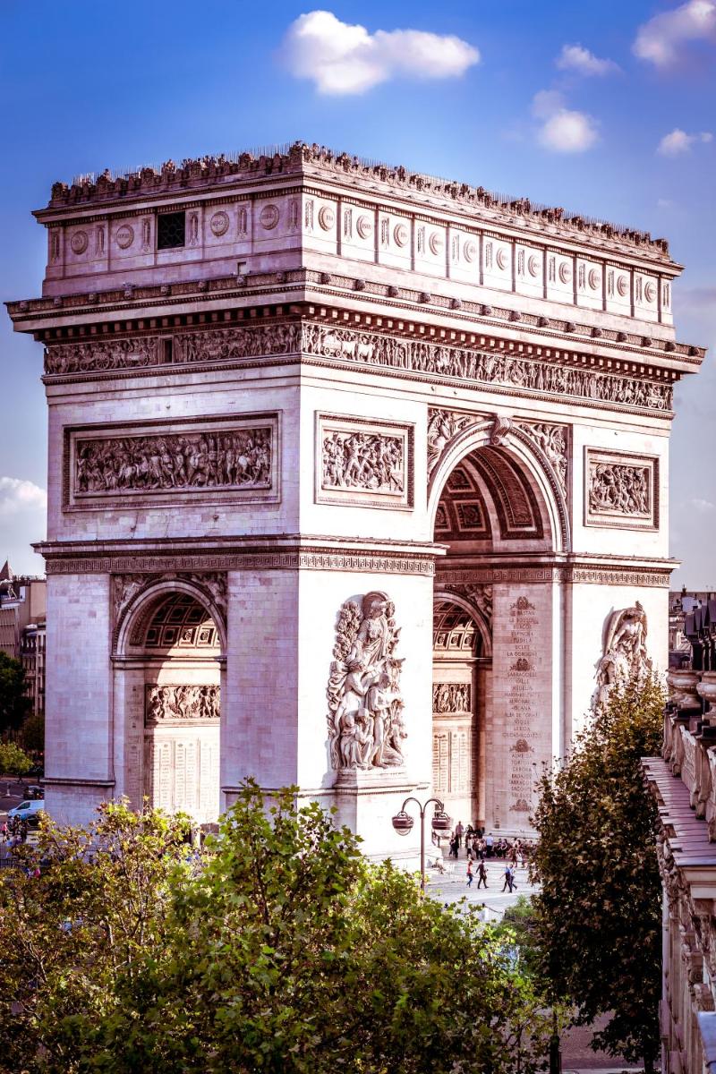 un grand bâtiment avec une arche dans une ville dans l'établissement Maison Albar- Le Champs-Elysées, à Paris