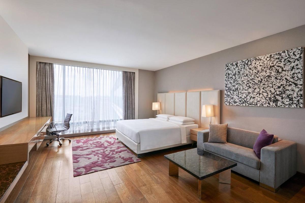 a hotel room with a bed and a couch at Marriott Executive Apartments Hyderabad in Hyderabad