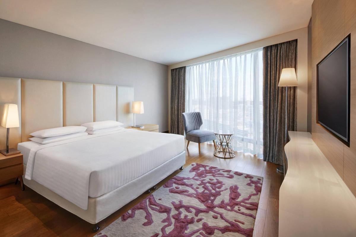a bedroom with a large white bed and a large window at Marriott Executive Apartments Hyderabad in Hyderabad