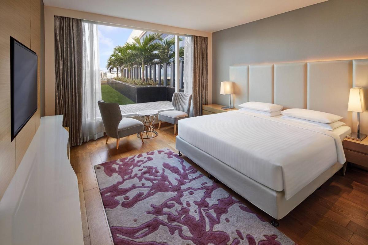 a bedroom with a large bed and a large window at Marriott Executive Apartments Hyderabad in Hyderabad