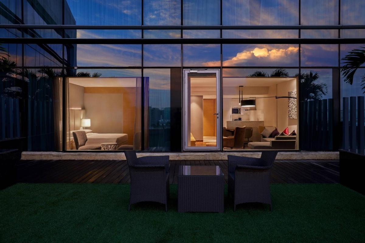 a view of a house with chairs and a bedroom at Marriott Executive Apartments Hyderabad in Hyderabad