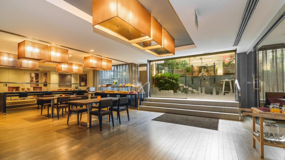 Un restaurante con mesas y sillas en una habitación. en Grums Hotel & Spa, en Barcelona