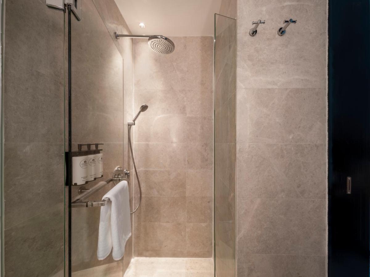 a shower with a glass door in a bathroom at The Robertson House by The Crest Collection in Singapore