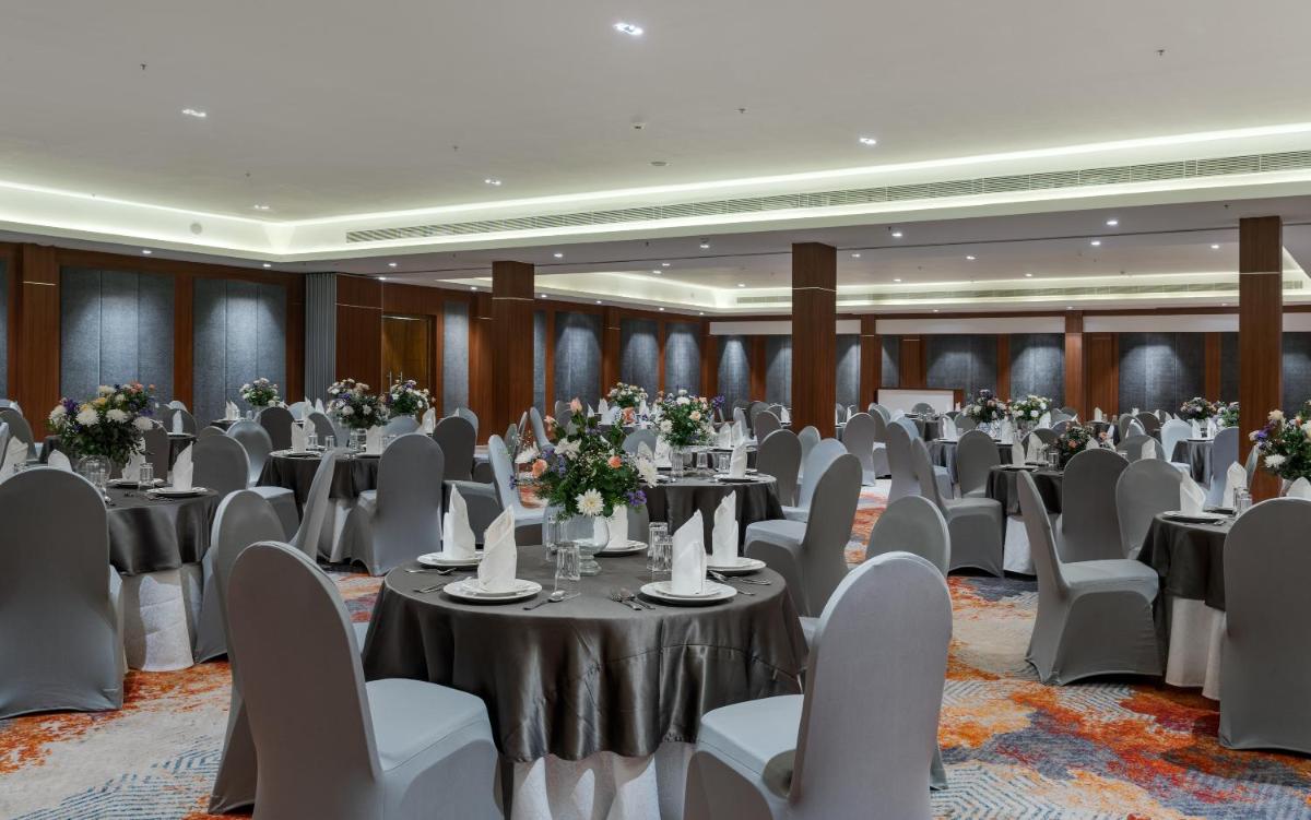 a banquet hall with tables and chairs and flowers at Southern Star,Mysore in Mysore