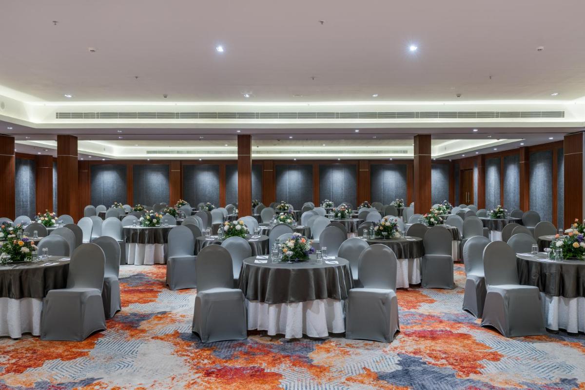 a banquet hall with tables and chairs in a room at Southern Star,Mysore in Mysore