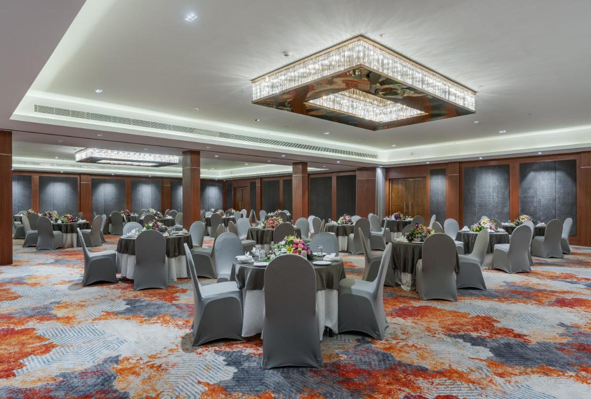 a conference room with tables and chairs and a chandelier at Southern Star,Mysore in Mysore