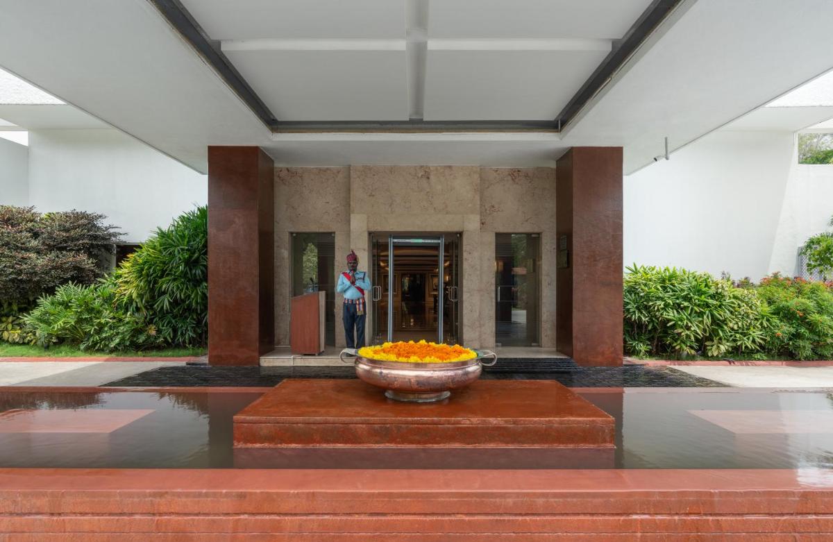 a woman standing in a building with a bowl of flowers at Southern Star,Mysore in Mysore