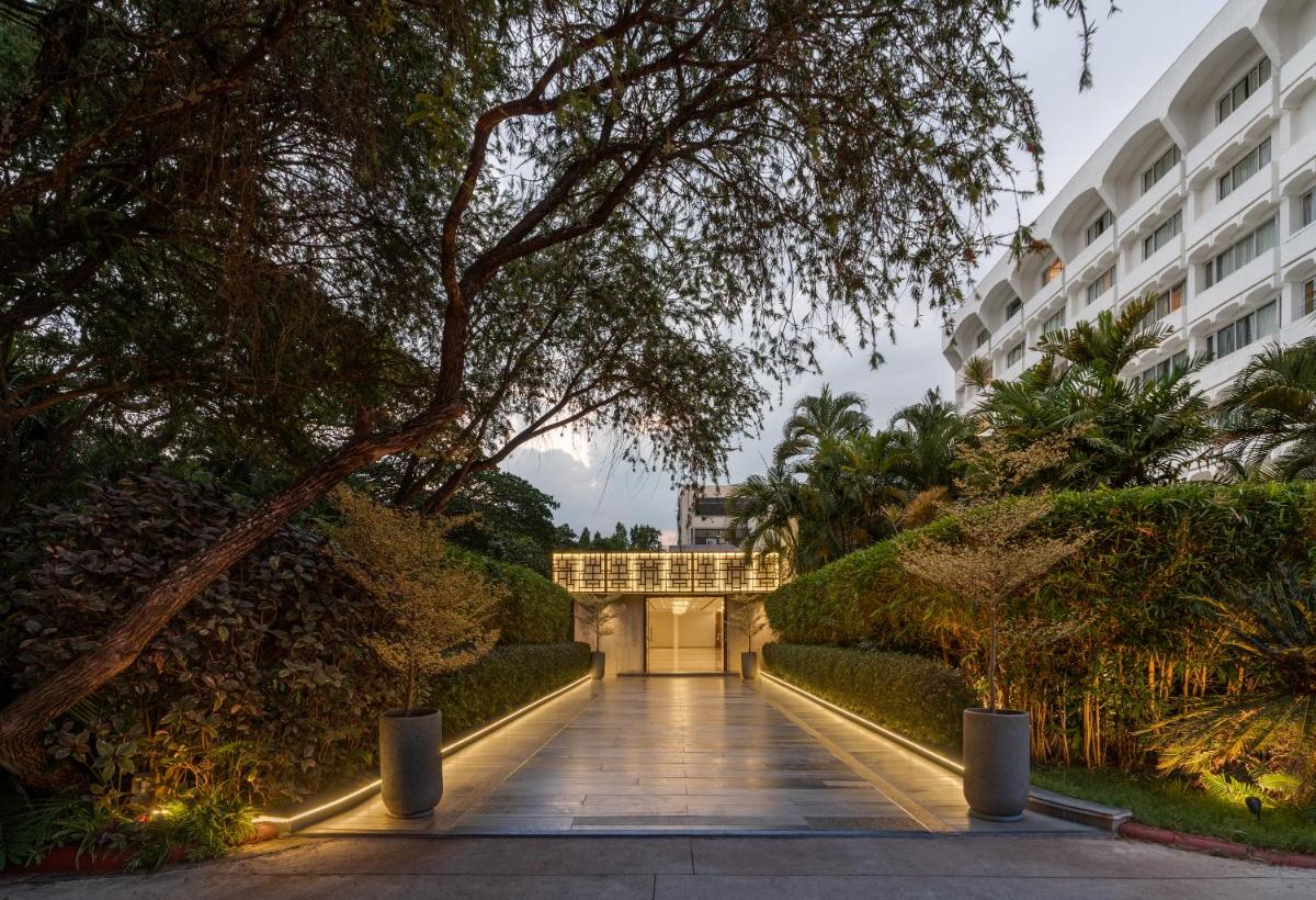 a walkway through a garden with a building at Southern Star,Mysore in Mysore