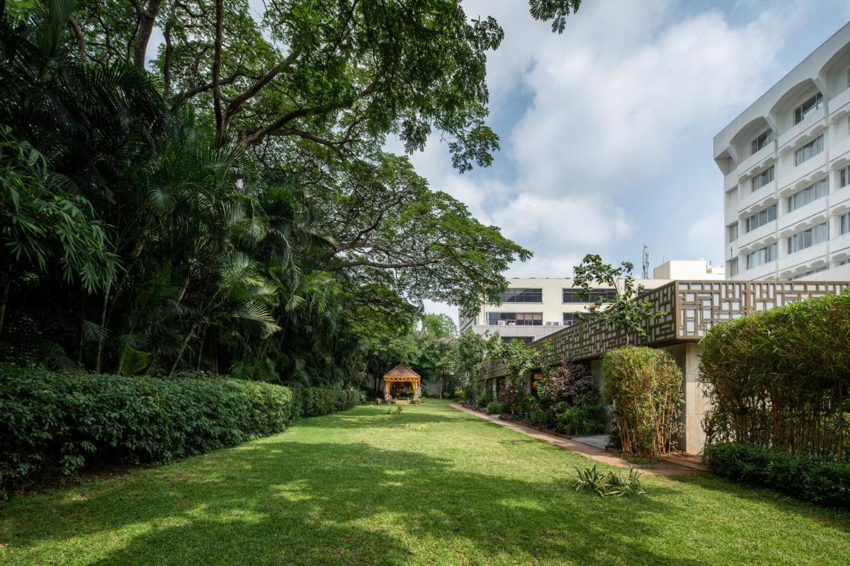 a garden with a building in the background at Southern Star,Mysore in Mysore