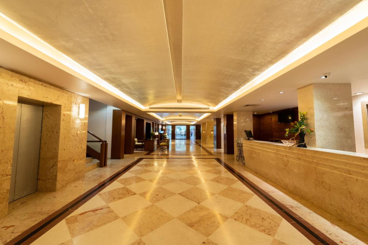 a hallway of a building with a checkered floor at Southern Star,Mysore in Mysore