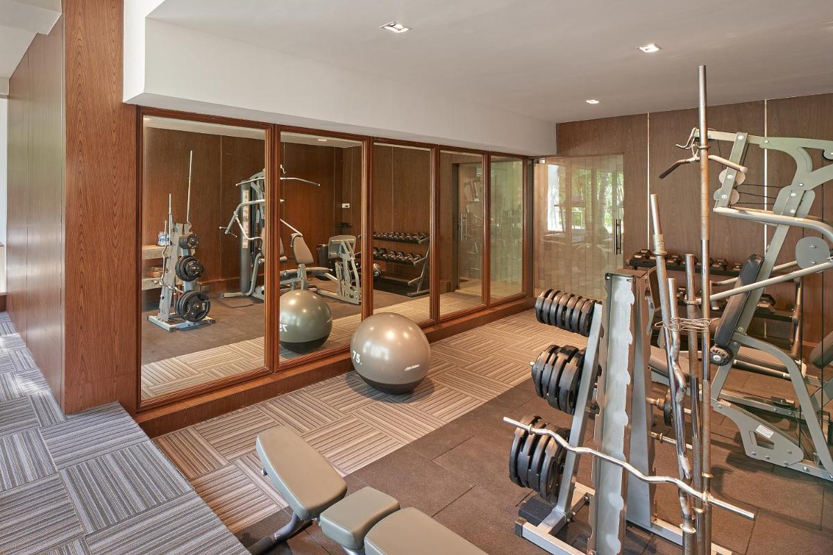 a gym with treadmills and exercise equipment in a room at Southern Star,Mysore in Mysore