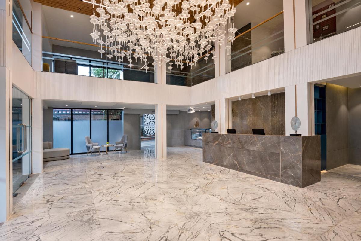 a large lobby with a chandelier and marble floor at Hyatt Place Goa Candolim in Candolim a large lobby with a chandelier and marble floor at Hyatt Place Goa Candolim in Candolim