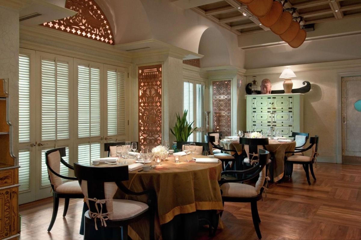 a dining room with tables and chairs and windows at Hilton Mumbai International Airport Hotel in Mumbai
