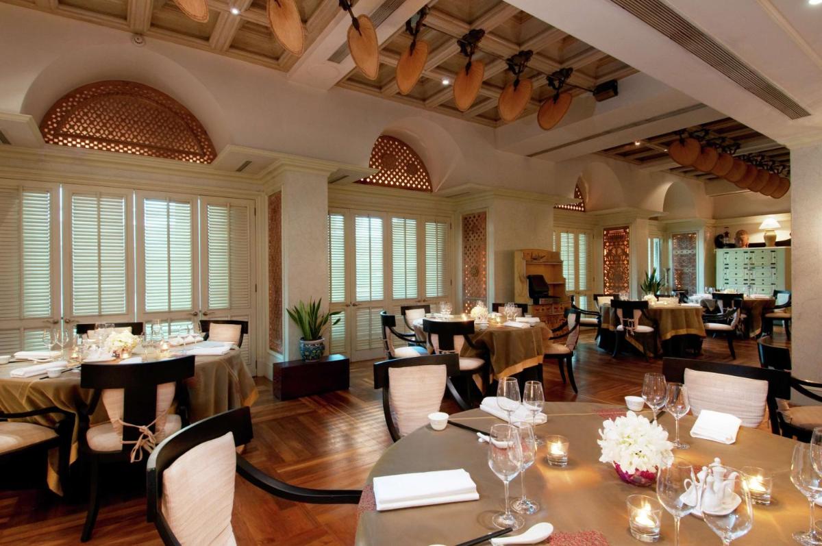 a restaurant with tables and chairs in a room at Hilton Mumbai International Airport Hotel in Mumbai