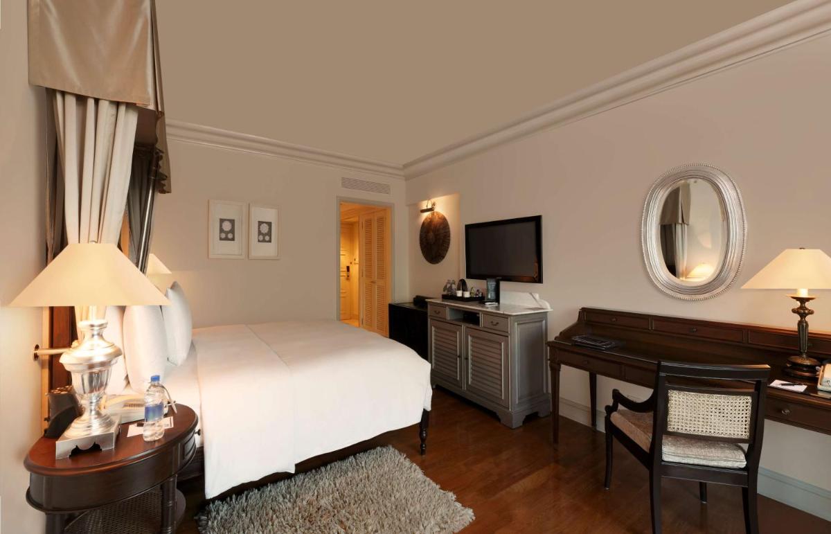 a bedroom with a bed and a desk and a television at Hilton Mumbai International Airport Hotel in Mumbai