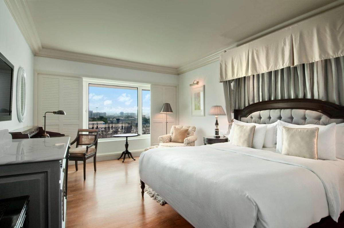 a bedroom with a large white bed and a desk at Hilton Mumbai International Airport Hotel in Mumbai