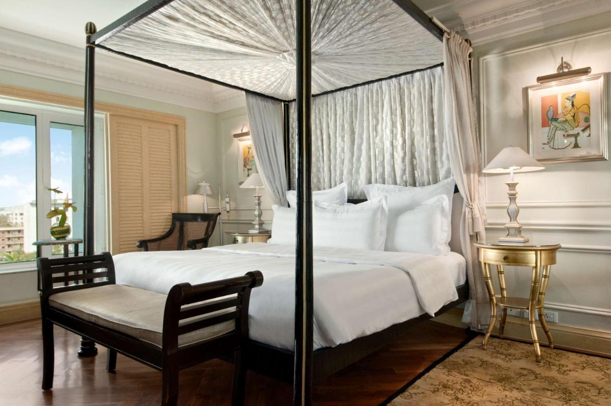 a bedroom with a canopy bed and a chair at Hilton Mumbai International Airport Hotel in Mumbai
