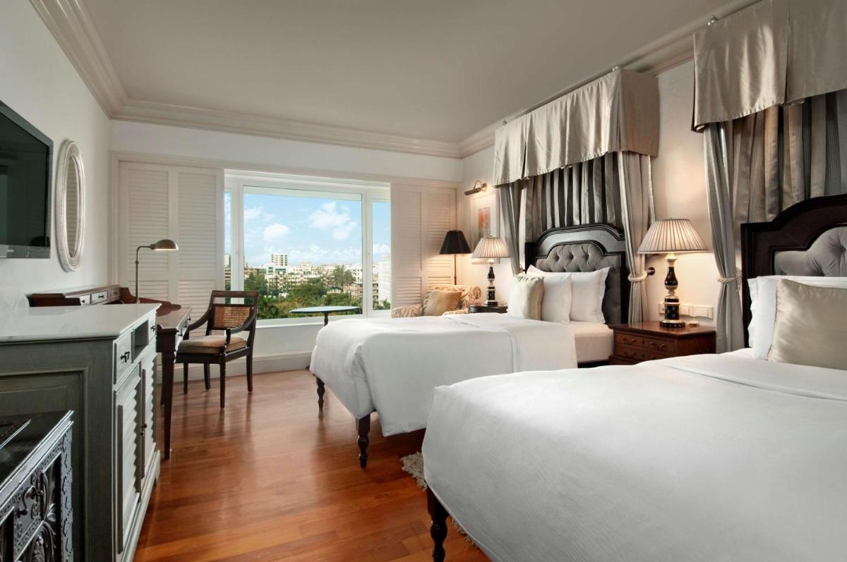 a hotel room with two beds and a window at Hilton Mumbai International Airport Hotel in Mumbai a hotel room with two beds and a window at Hilton Mumbai International Airport Hotel in Mumbai