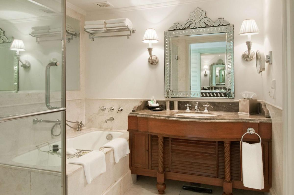 a bathroom with a tub and a sink and a mirror at Hilton Mumbai International Airport Hotel in Mumbai