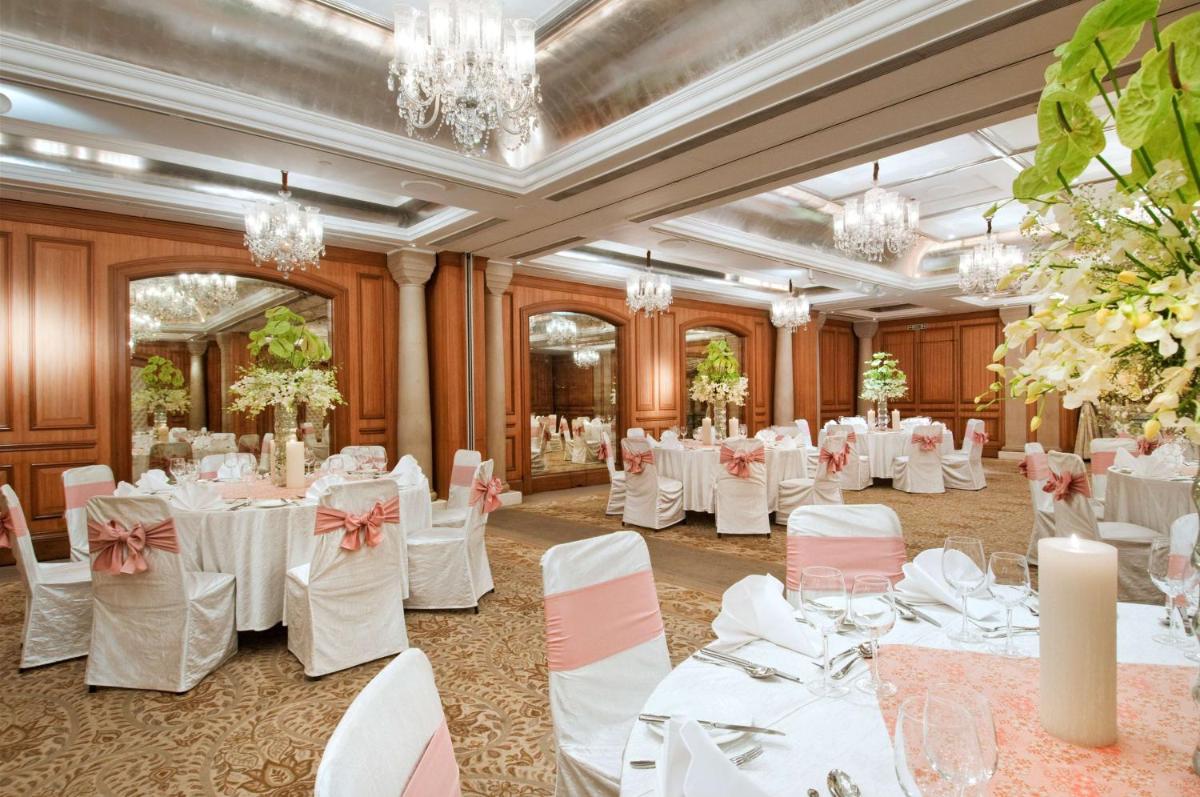 a banquet hall with white tables and chairs and chandeliers at Hilton Mumbai International Airport Hotel in Mumbai +80 photos