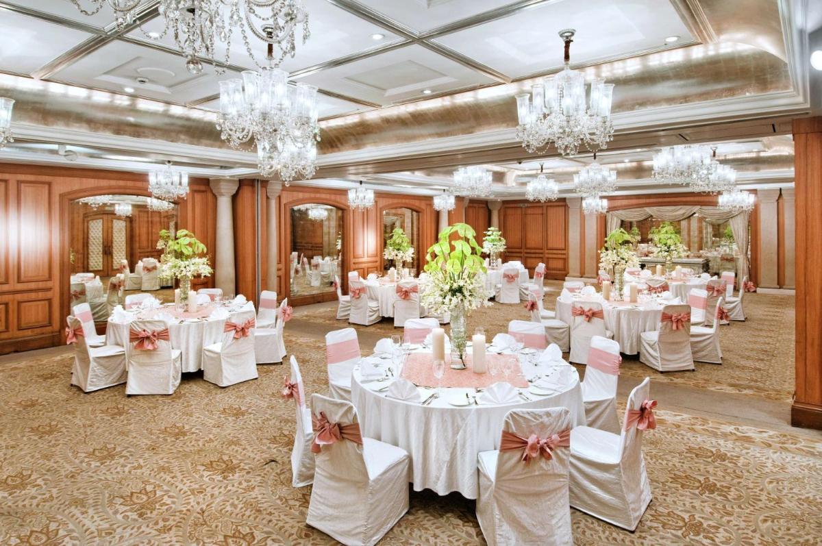 a banquet hall with white tables and chairs and chandeliers at Hilton Mumbai International Airport Hotel in Mumbai