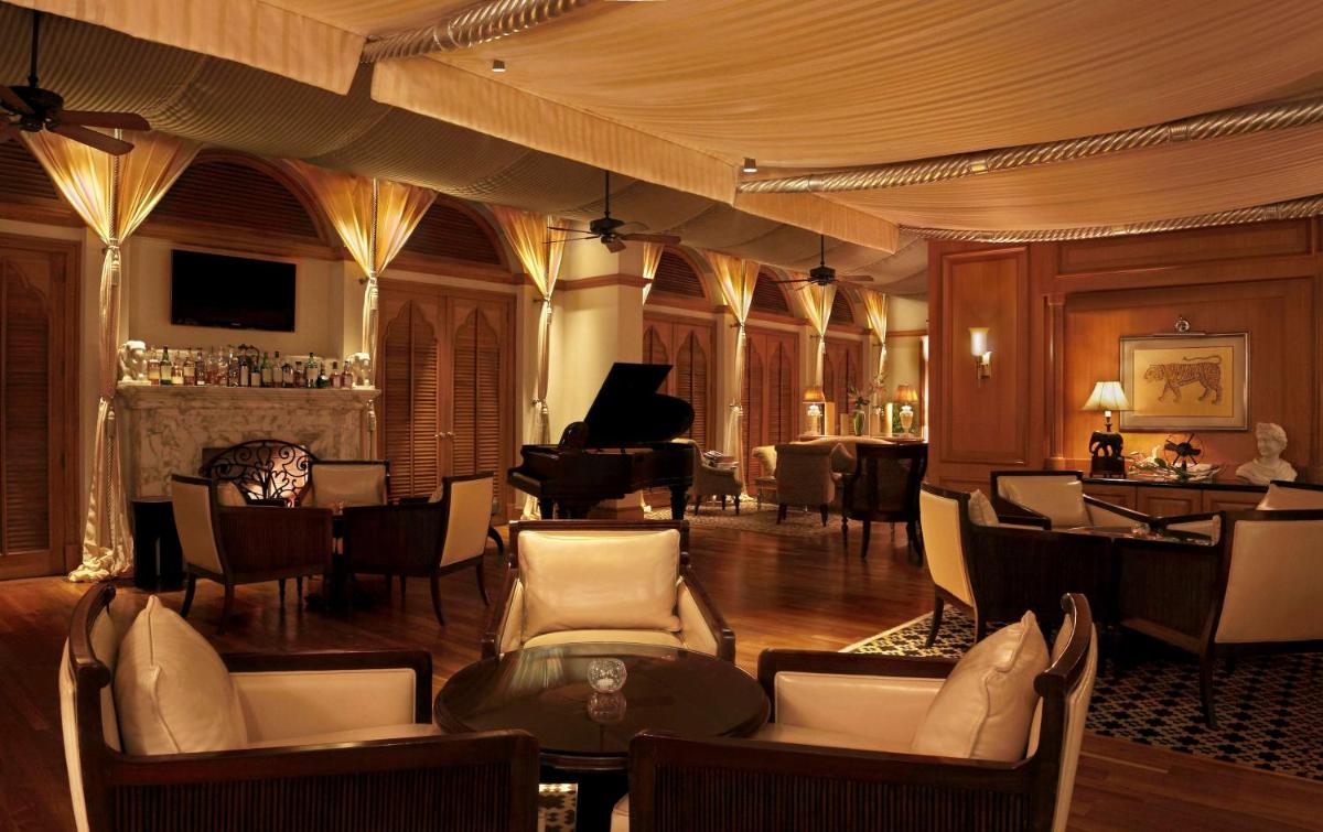 a living room with a piano and a table and chairs at Hilton Mumbai International Airport Hotel in Mumbai