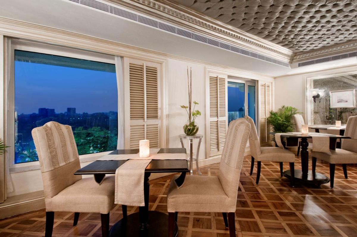 a dining room with a table and chairs and a large window at Hilton Mumbai International Airport Hotel in Mumbai