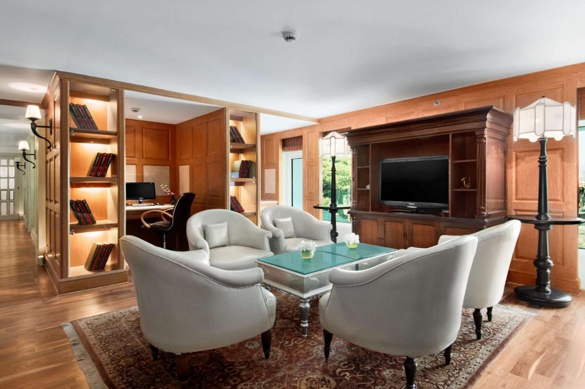 a living room with a table and chairs and a television at Hilton Mumbai International Airport Hotel in Mumbai