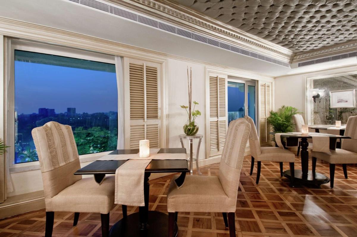 a dining room with a table and chairs and a large window at Hilton Mumbai International Airport Hotel in Mumbai