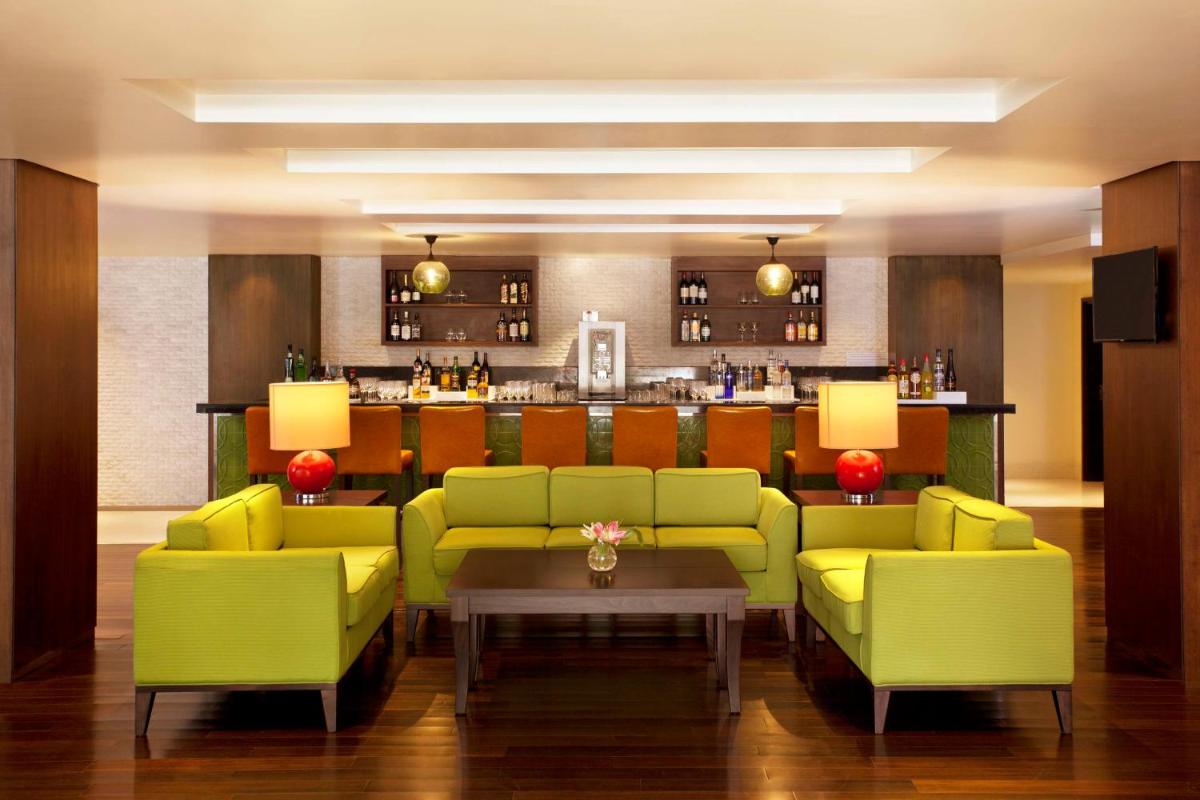 a lobby with green couches and a bar at Hilton Garden Inn, Trivandrum in Trivandrum