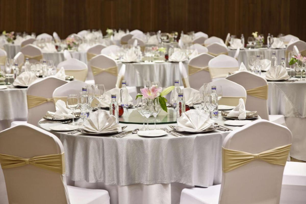 a room filled with tables and chairs with white tablecloths at Hilton Garden Inn, Trivandrum in Trivandrum