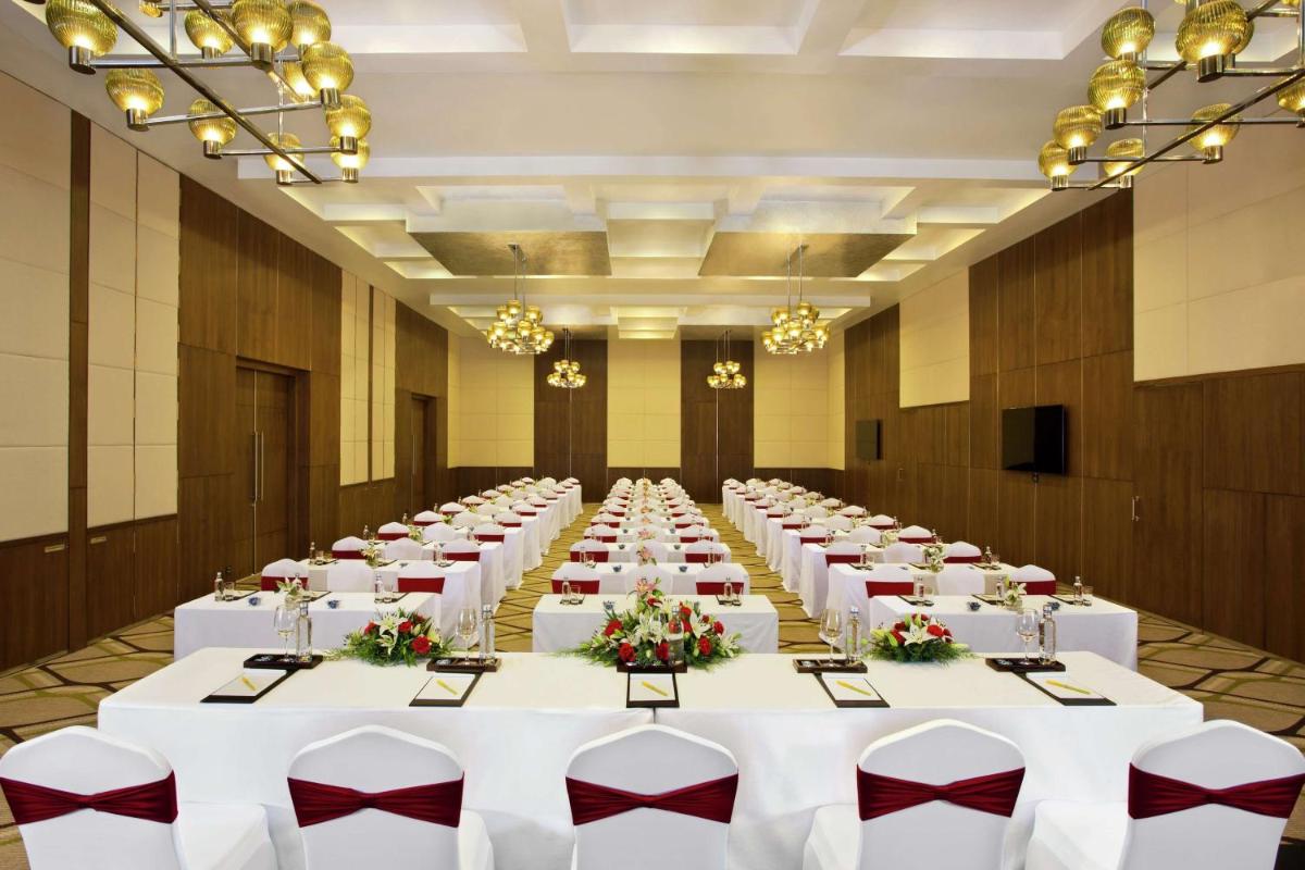 a large banquet hall with white tables and chairs at Hilton Garden Inn, Trivandrum in Trivandrum
