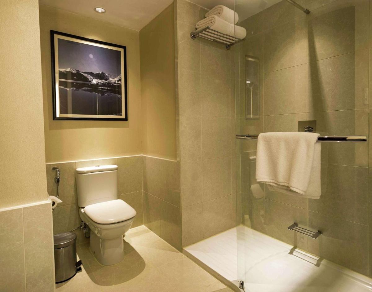 a bathroom with a toilet and a shower at Hilton Garden Inn, Trivandrum in Trivandrum