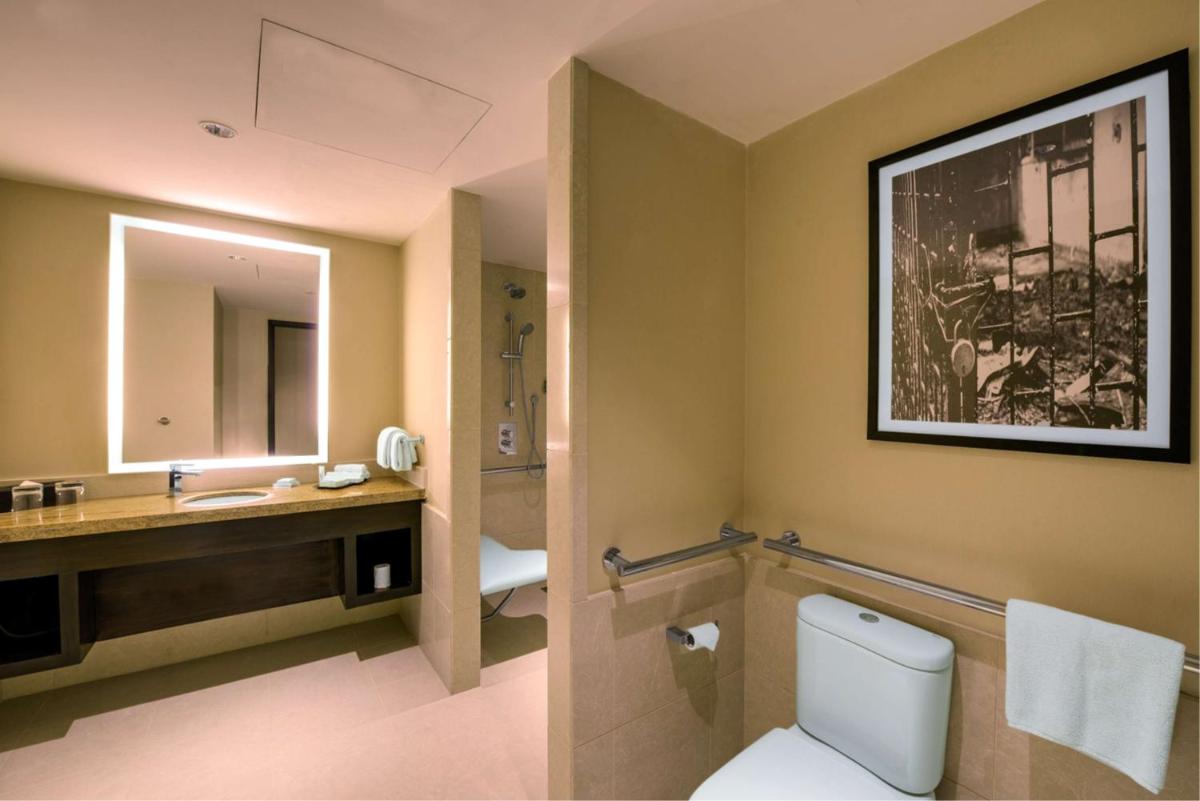 a bathroom with a toilet and a sink and a mirror at Hilton Garden Inn, Trivandrum in Trivandrum