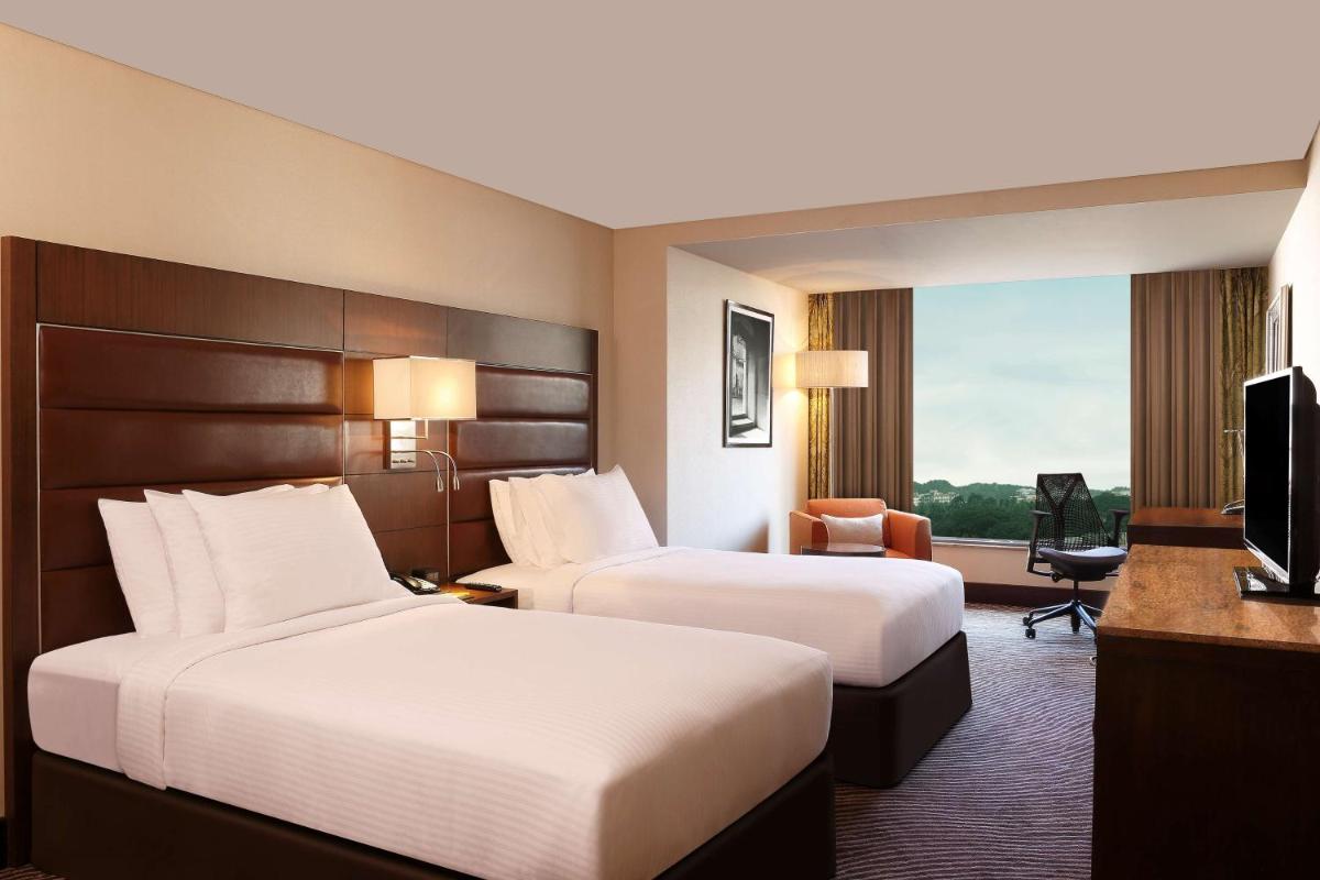 a hotel room with two beds and a television at Hilton Garden Inn, Trivandrum in Trivandrum