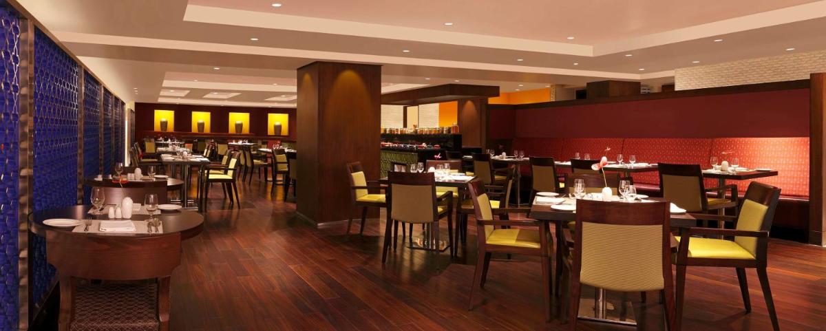 a dining room with tables and chairs in a restaurant at Hilton Garden Inn, Trivandrum in Trivandrum