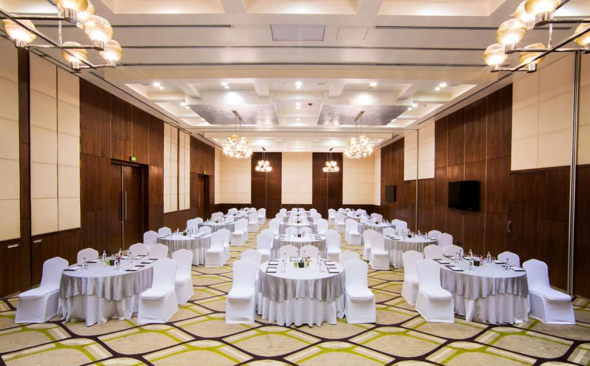 a banquet hall with white tables and white chairs at Hilton Garden Inn, Trivandrum in Trivandrum