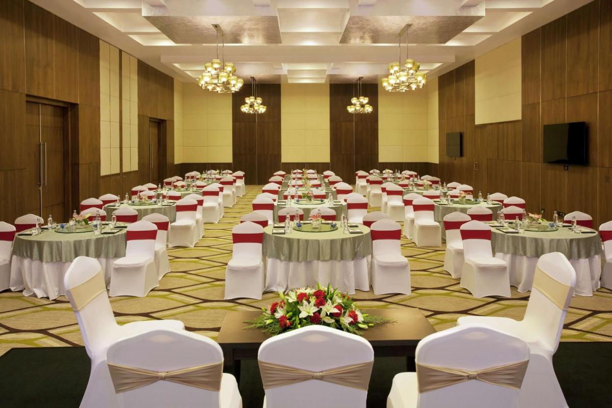 a banquet hall with white tables and white chairs at Hilton Garden Inn, Trivandrum in Trivandrum