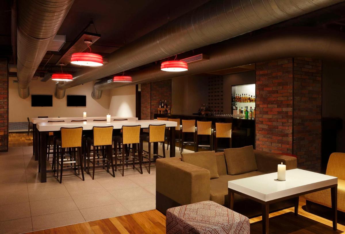 a restaurant with a bar with a long table and chairs at Hilton Garden Inn, Trivandrum in Trivandrum