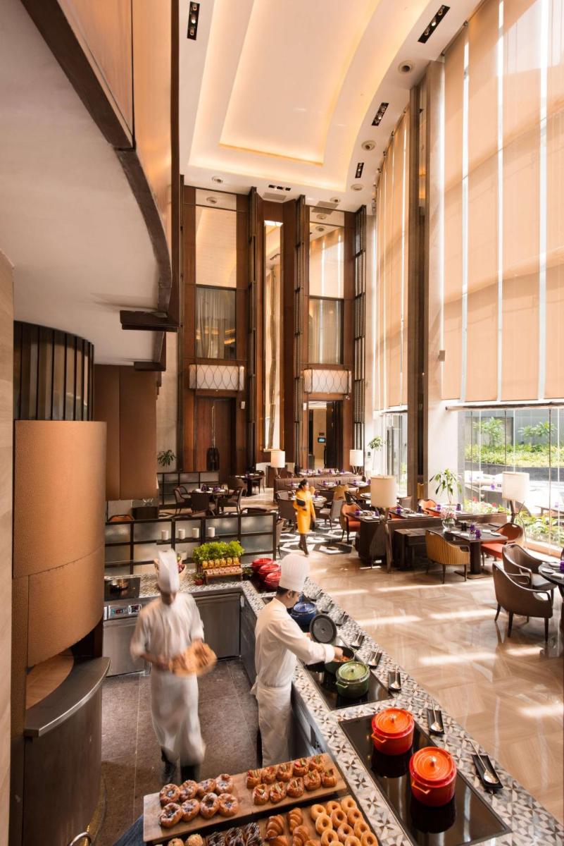 two chefs preparing food in a large kitchen at Conrad Pune in Pune