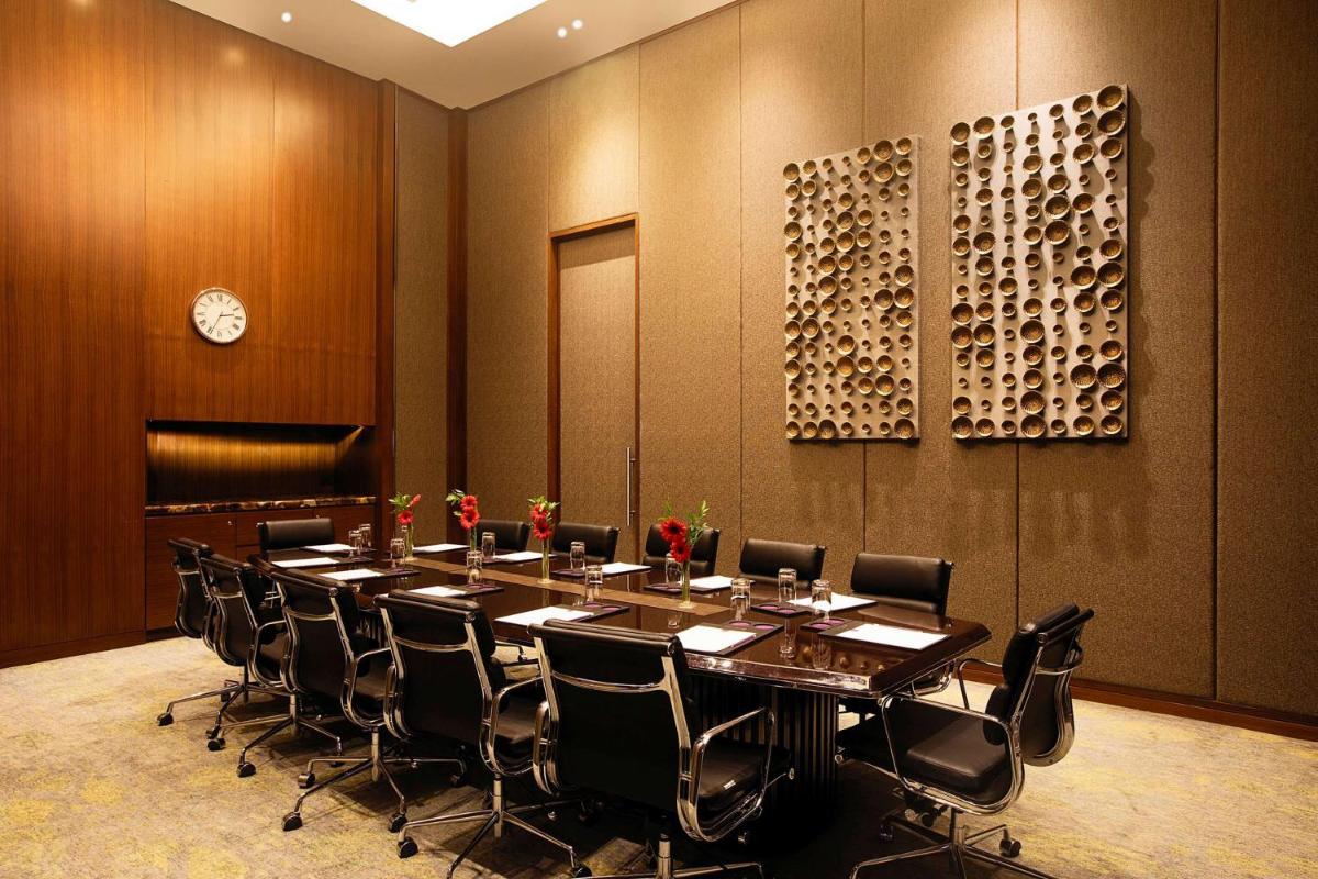 a conference room with a long table and chairs at Conrad Pune in Pune
