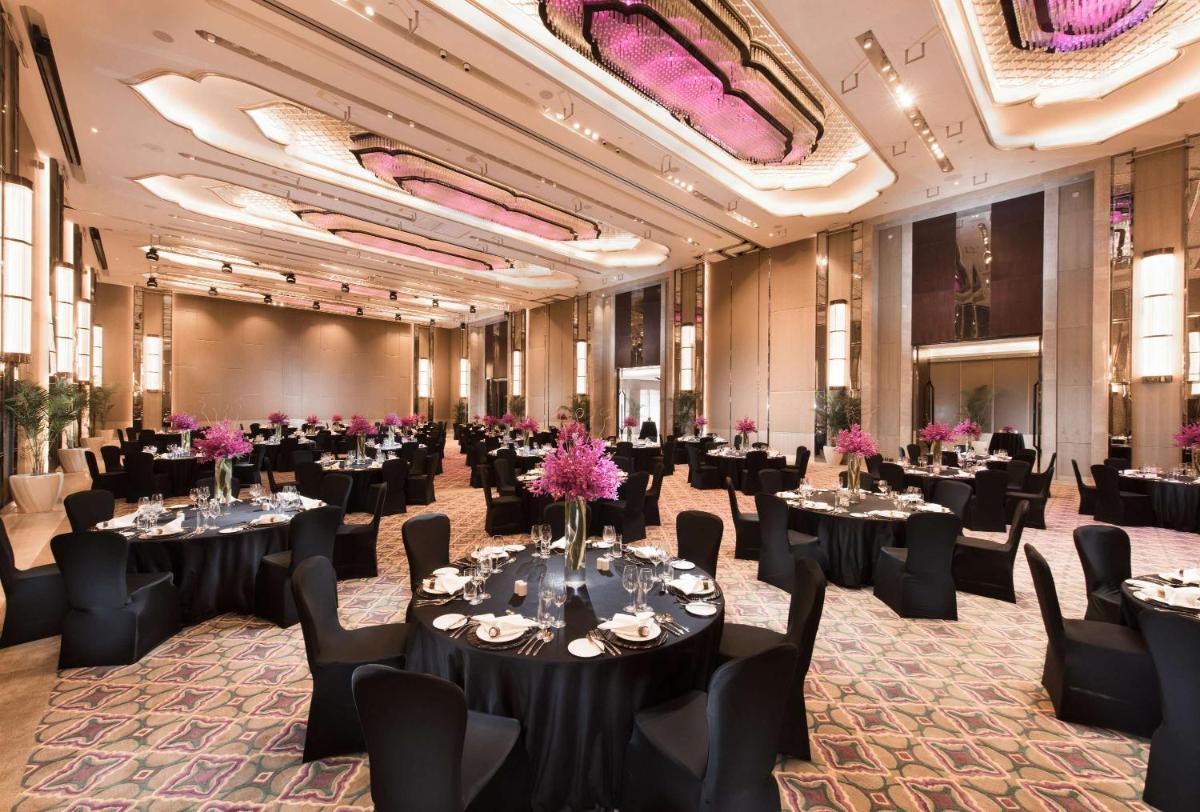 a ballroom with tables and chairs and a large ballroom with tables and chairs at Conrad Pune in Pune +39 photos