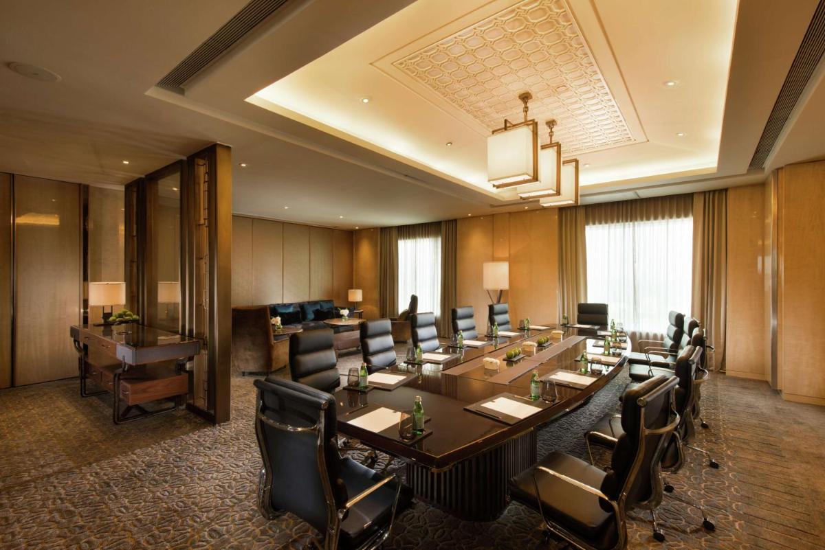 a conference room with a long table and chairs at Conrad Pune in Pune