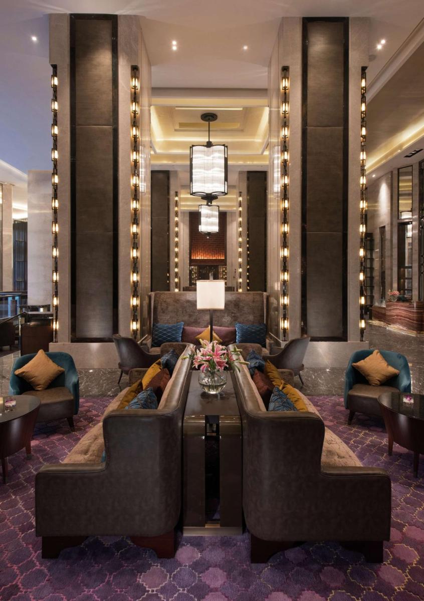 a lobby with couches and a table in a building at Conrad Pune in Pune