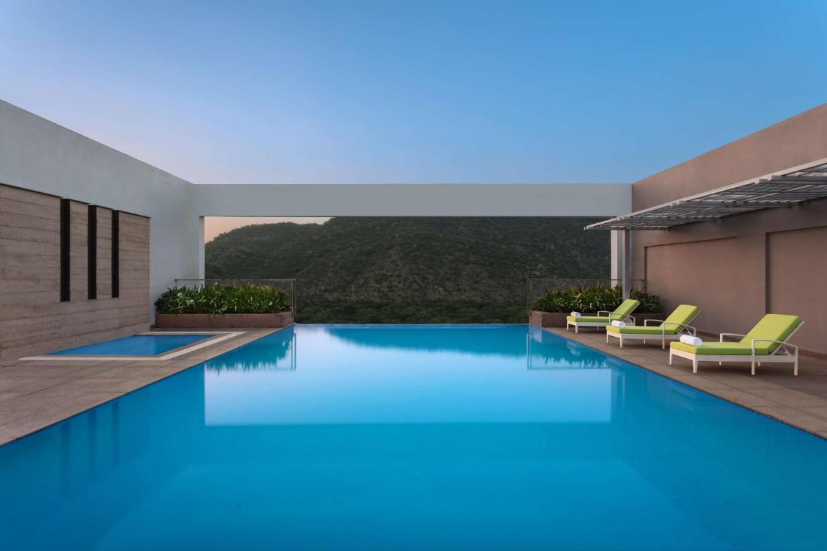 a swimming pool in a villa with a view at DoubleTree By Hilton Jaipur Amer in Jaipur