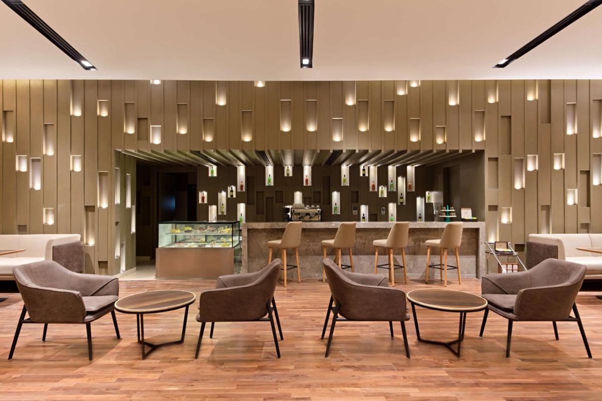 a lobby with chairs and tables and a bar at DoubleTree By Hilton Jaipur Amer in Jaipur
