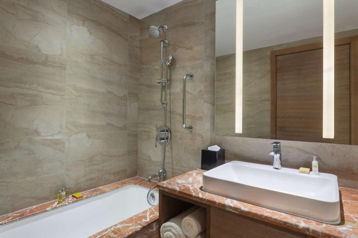 a bathroom with a sink and a bath tub at DoubleTree By Hilton Jaipur Amer in Jaipur